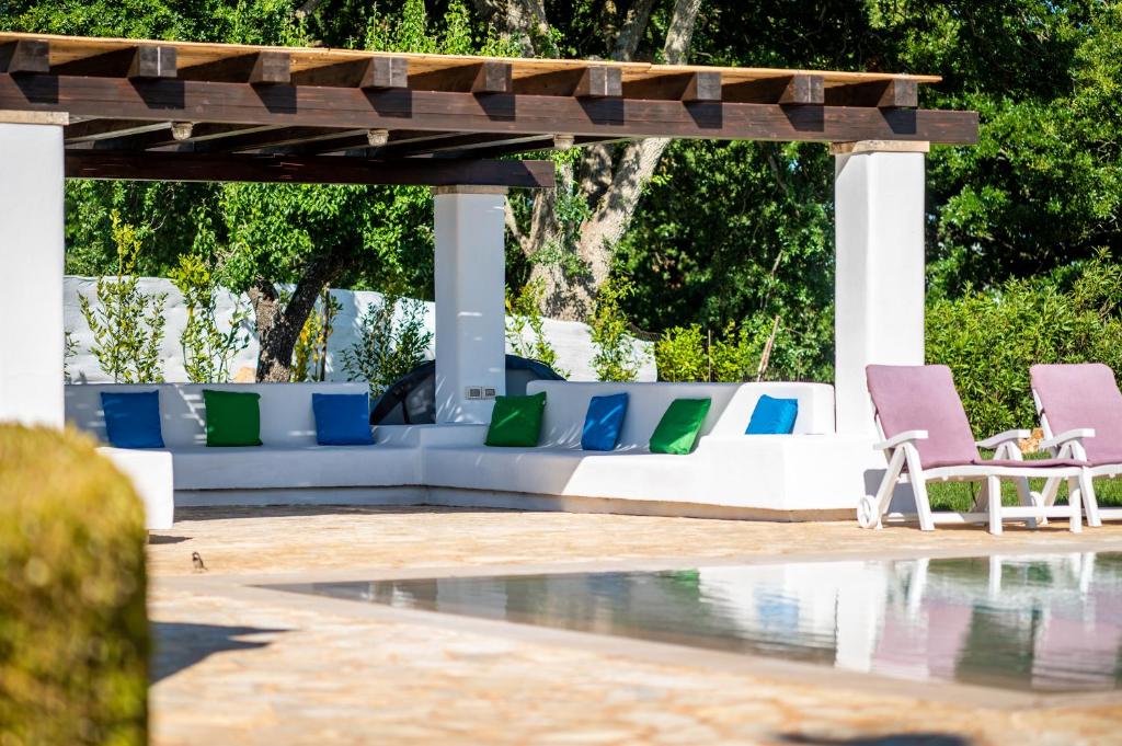 - un groupe de chaises assises sous un pavillon à côté d'une piscine dans l'établissement Trulli Margherita, à Martina Franca
