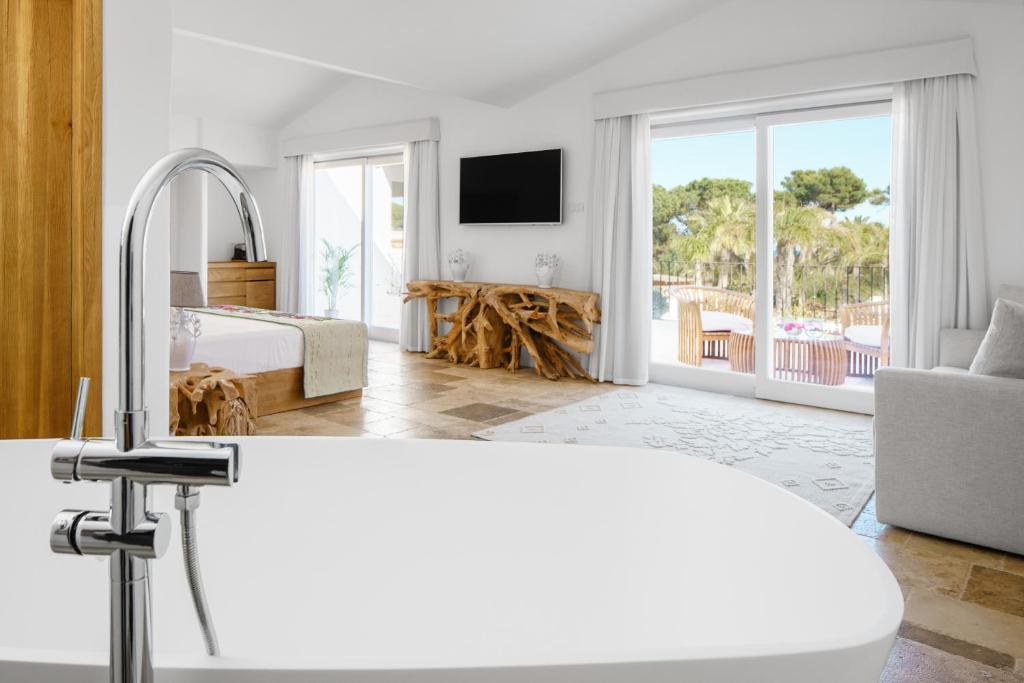 - une chambre blanche avec un lit et une vue sur la piscine dans l'établissement Sant Efis Hotel, à Pula