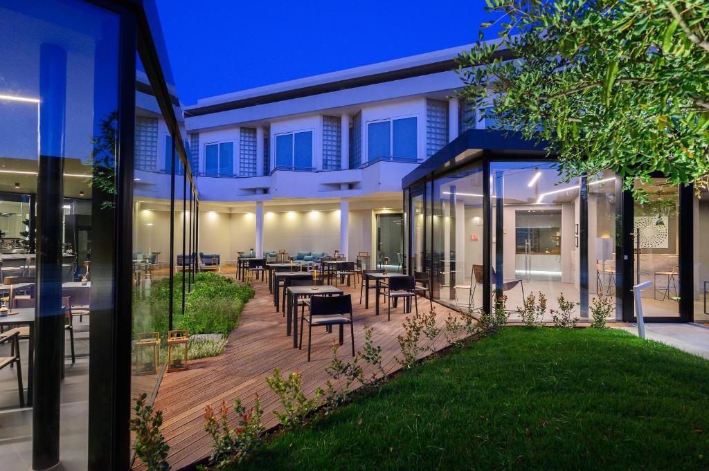 une maison avec une terrasse avec des tables et des chaises dans l'établissement Hotel Royal Paestum, à Paestum