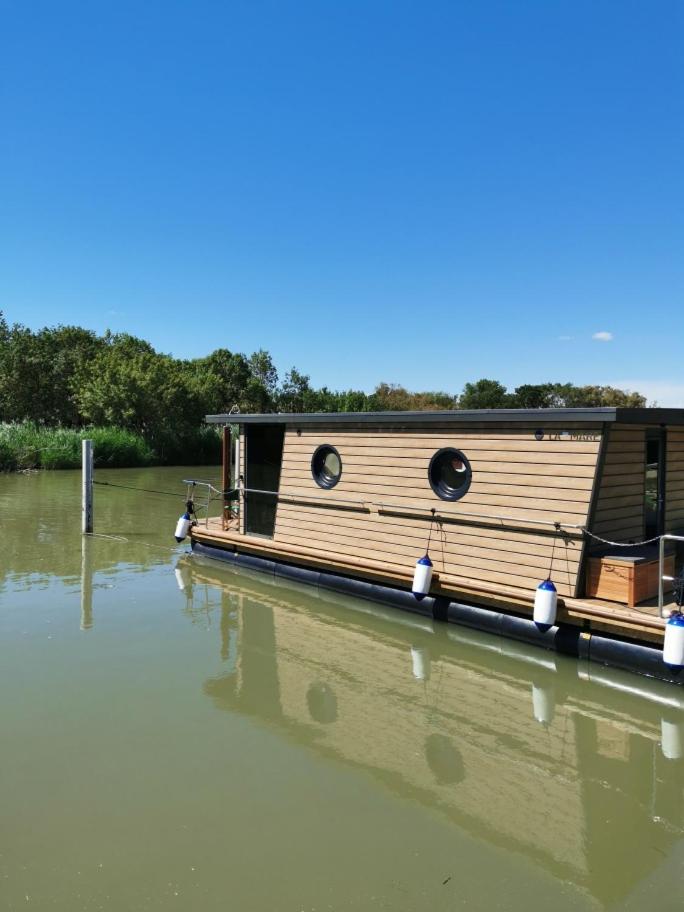 un bateau en bois est assis sur l'eau dans l'établissement Rêves d'Ô en Camargue, clim réversible, parc naturel, à Vauvert