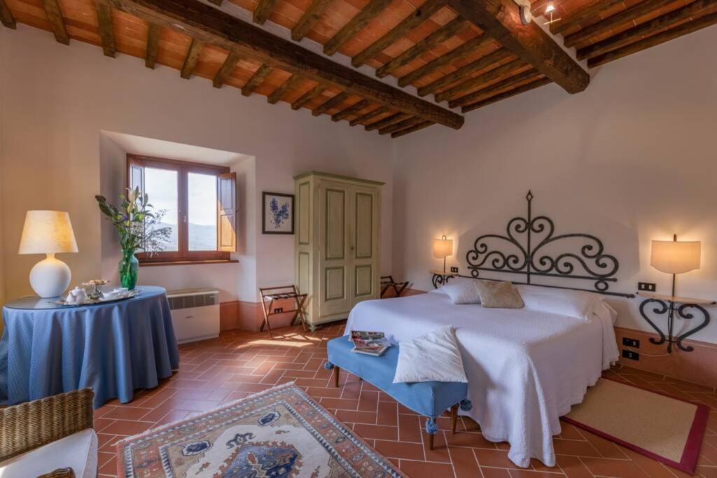 une chambre avec un grand lit et une table dans l'établissement Borgo San Pietro in Polvano (Canonica), à Polvano