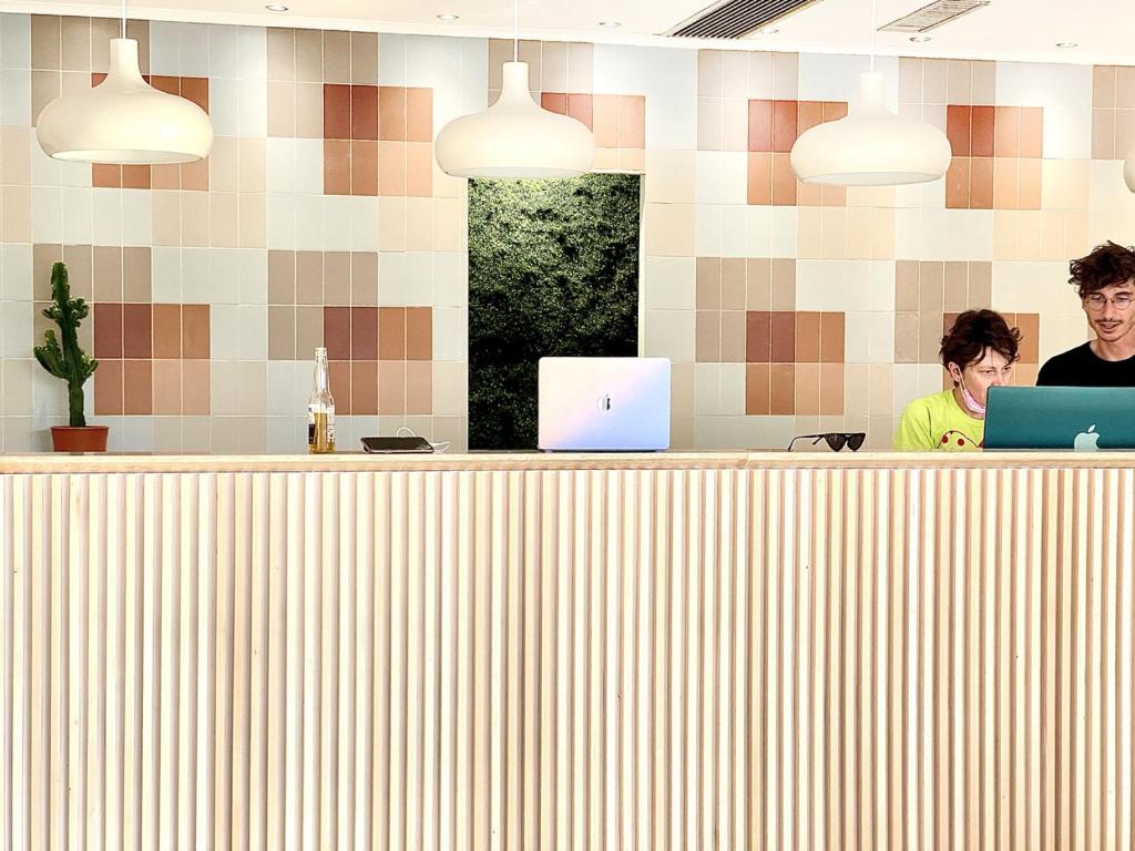 deux personnes assises à un comptoir avec leurs ordinateurs portables dans l'établissement Hotel Blumen, à San Benedetto del Tronto 134 autres photos