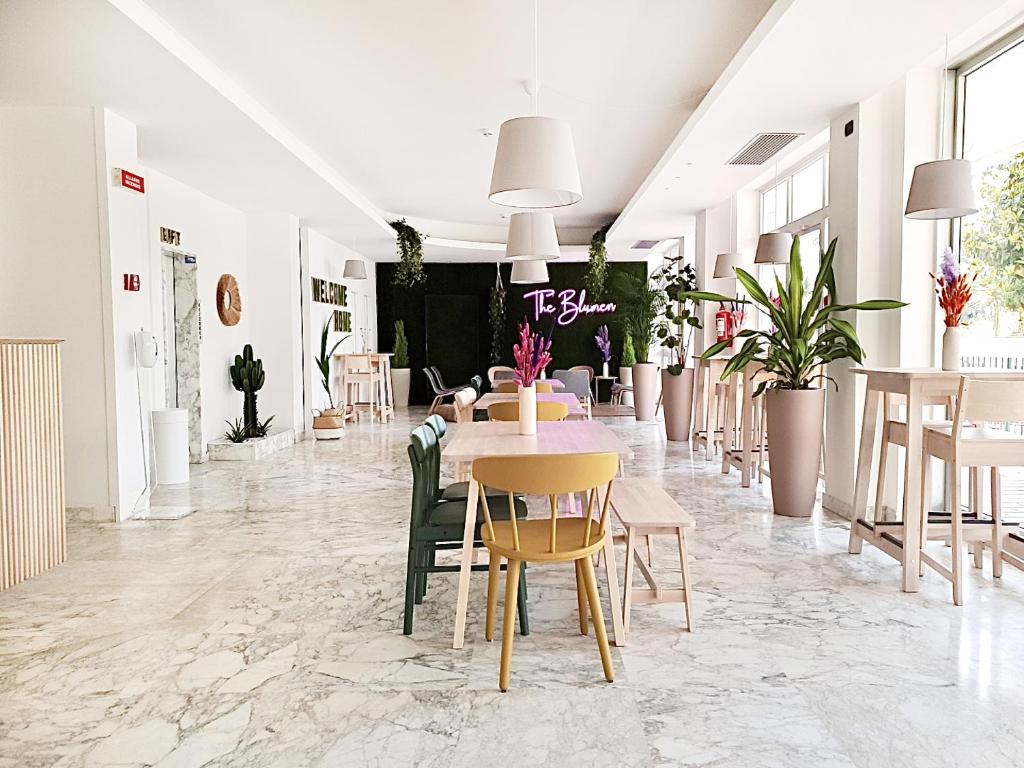 une pièce avec une table, des chaises et des plantes dans l'établissement Hotel Blumen, à San Benedetto del Tronto