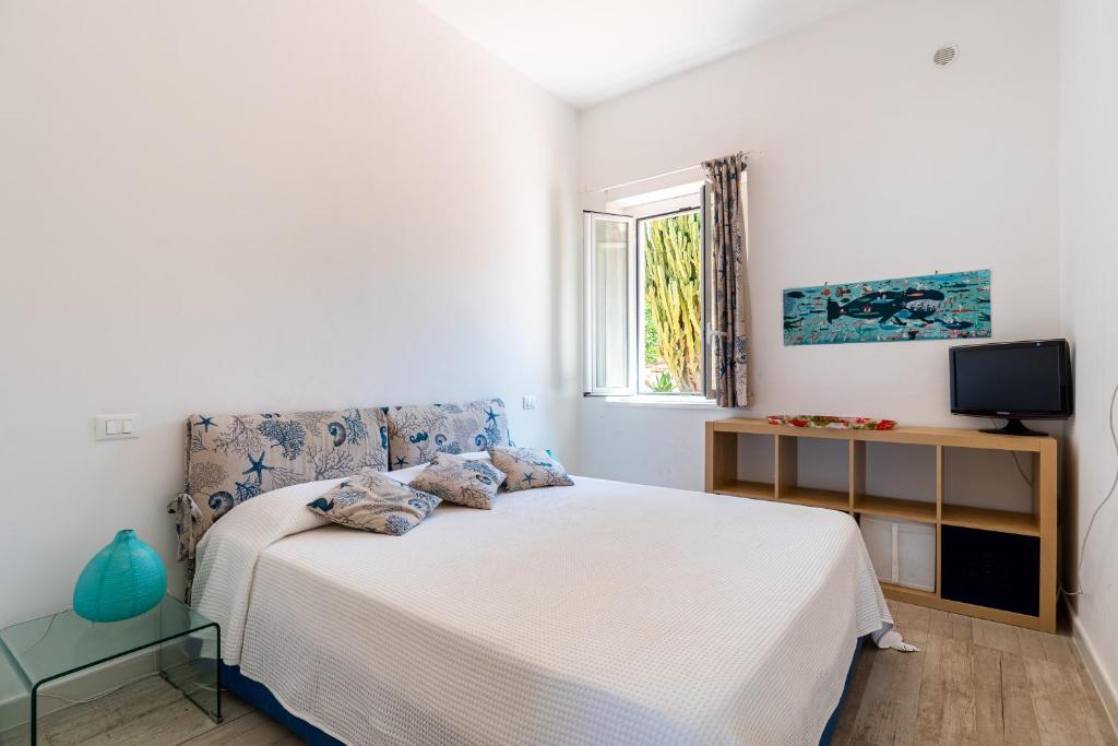 une chambre blanche avec un lit et une fenêtre dans l'établissement Splendida Villa con vista mozzafiato e piscina, à Terrasini