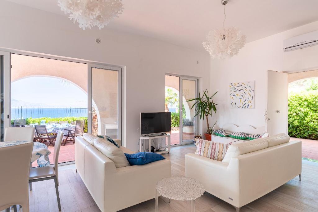 un salon avec deux canapés blancs et une télévision dans l'établissement Splendida Villa con vista mozzafiato e piscina, à Terrasini