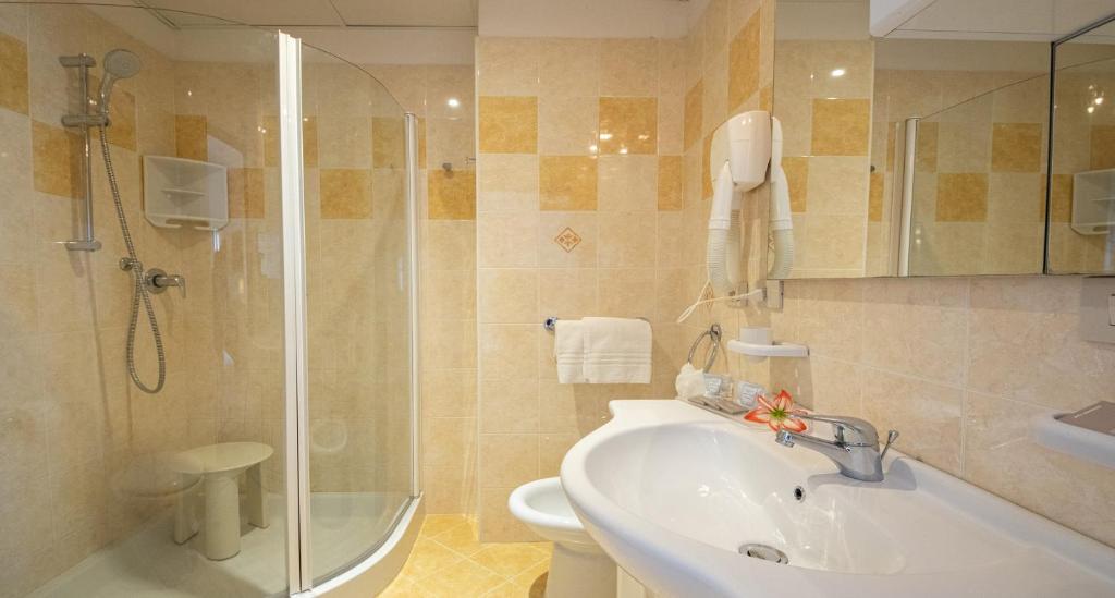 une salle de bain avec douche, lavabo et toilettes dans l'établissement Hotel Smeraldo, à Lido di Jesolo