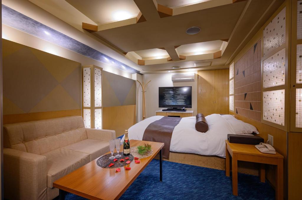 une chambre d'hôtel avec un lit et un canapé dans l'établissement Water Hotel Mw (Love Hotel), à Saitama