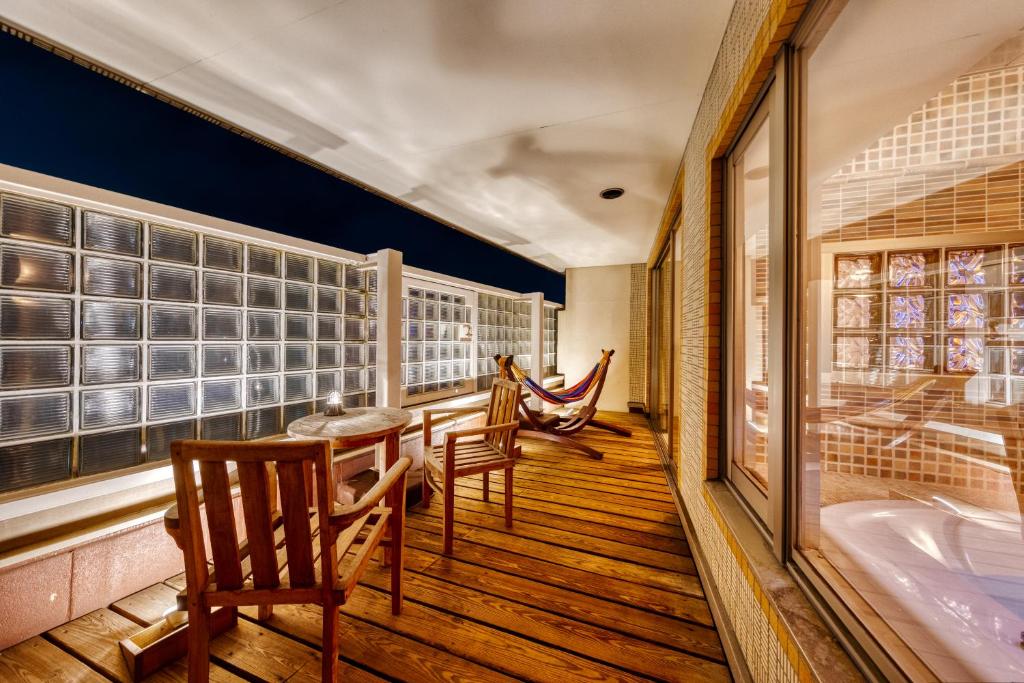 - une chambre avec une table, des chaises et une baignoire dans l'établissement Hotel Lotus Chiba -Adult Only, à Yachiyo