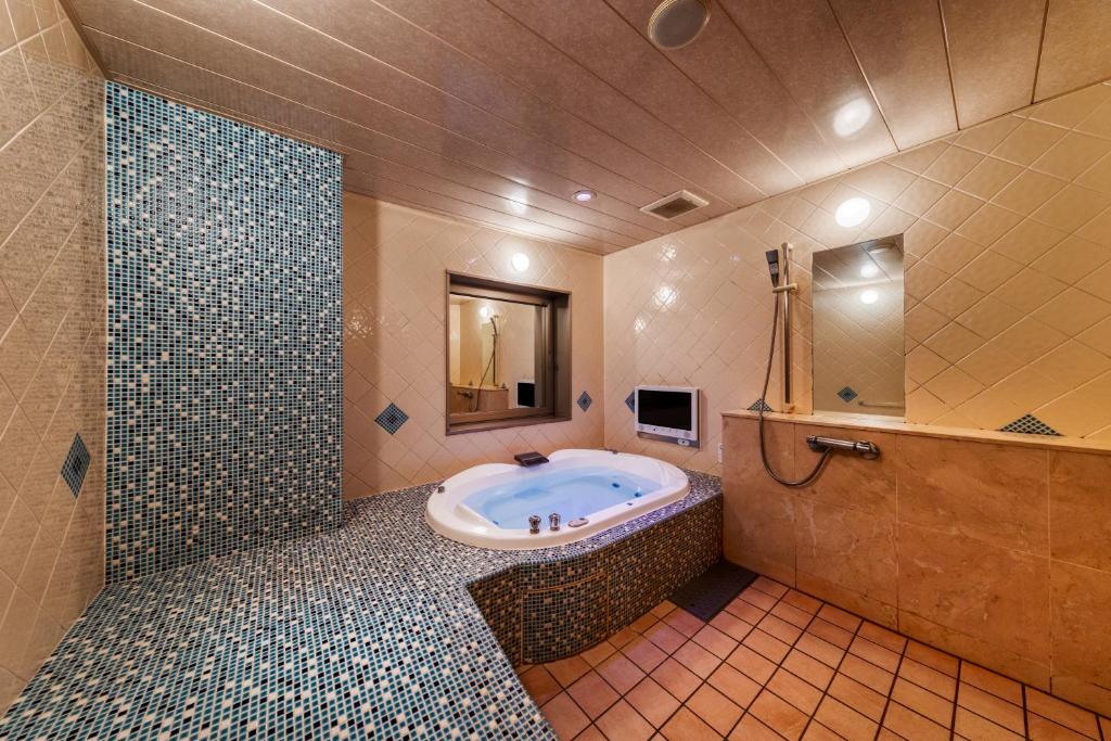 une grande salle de bain avec baignoire et douche dans l'établissement Hotel Lotus Chiba -Adult Only, à Yachiyo
