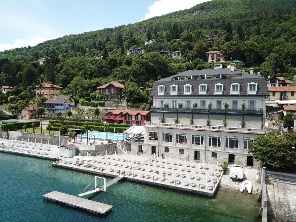 un grand bâtiment avec un quai dans l'eau dans l'établissement Hotel Ghiffa, à Ghiffa