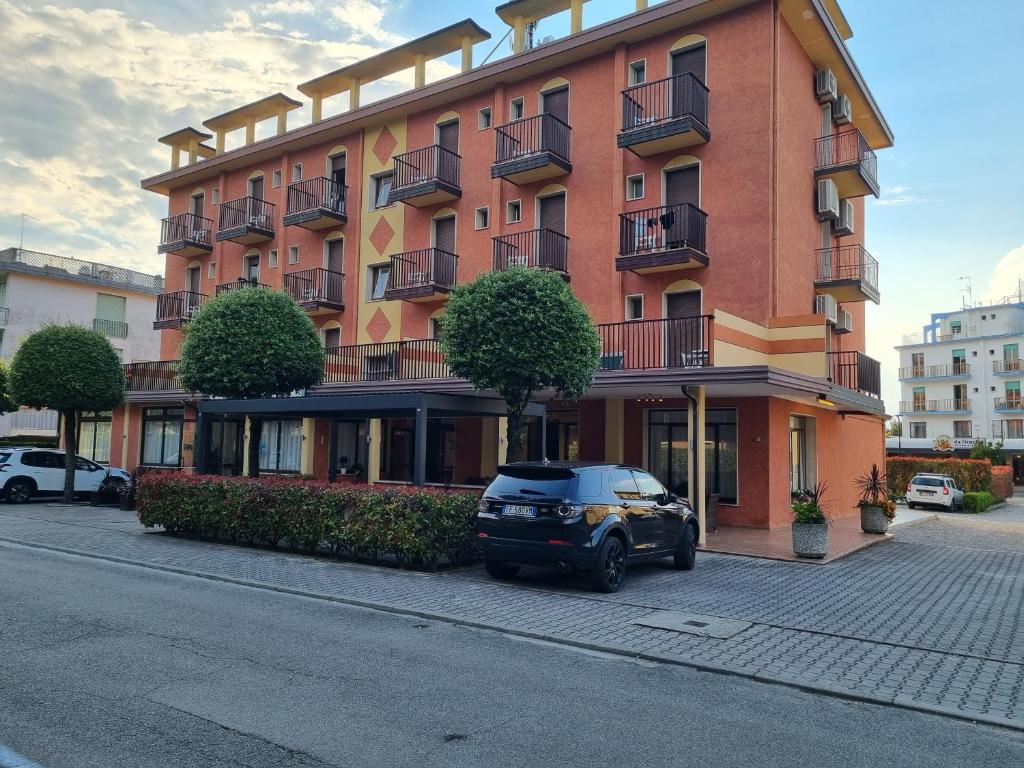 un bâtiment avec une voiture garée devant dans l'établissement Hotel Sole, à Eraclea Mare