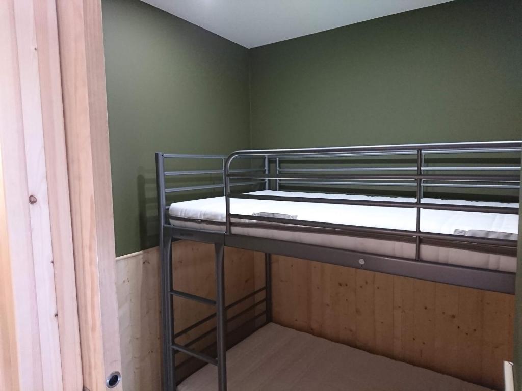 Ce lit superposé se trouve dans un dortoir aux murs verts. dans l'établissement La Croisette, à Mont-de-Lans