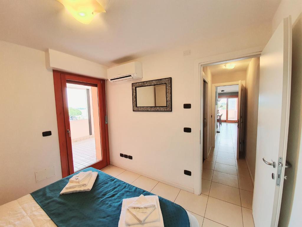 une chambre avec un lit et un miroir au mur dans l'établissement Aparthotel Capitol, à Grado