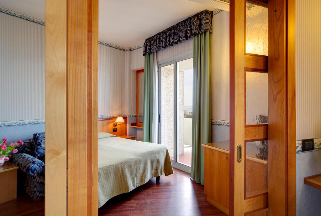 une chambre avec un lit et une grande fenêtre dans l'établissement Hotel Palace, à Senigallia