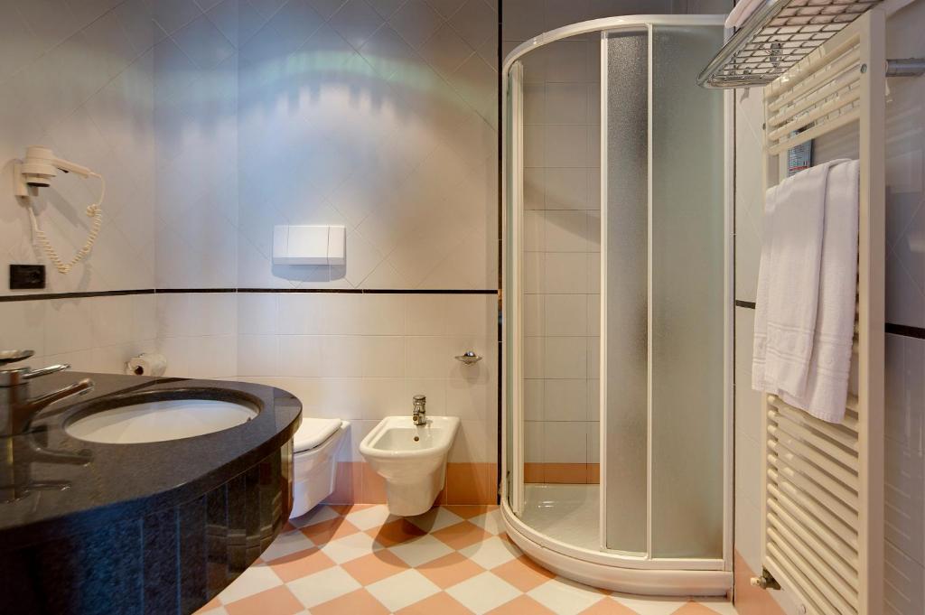 une salle de bain avec un lavabo, des toilettes et une douche dans l'établissement Hotel Palace, à Senigallia 39 autres photos