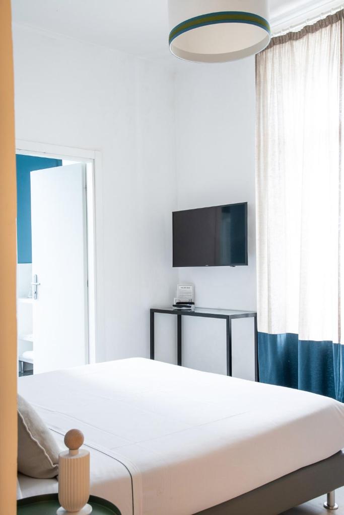 une chambre avec un lit et une télévision à écran plat dans l'établissement Villa delle Palme, à Santa Marinella