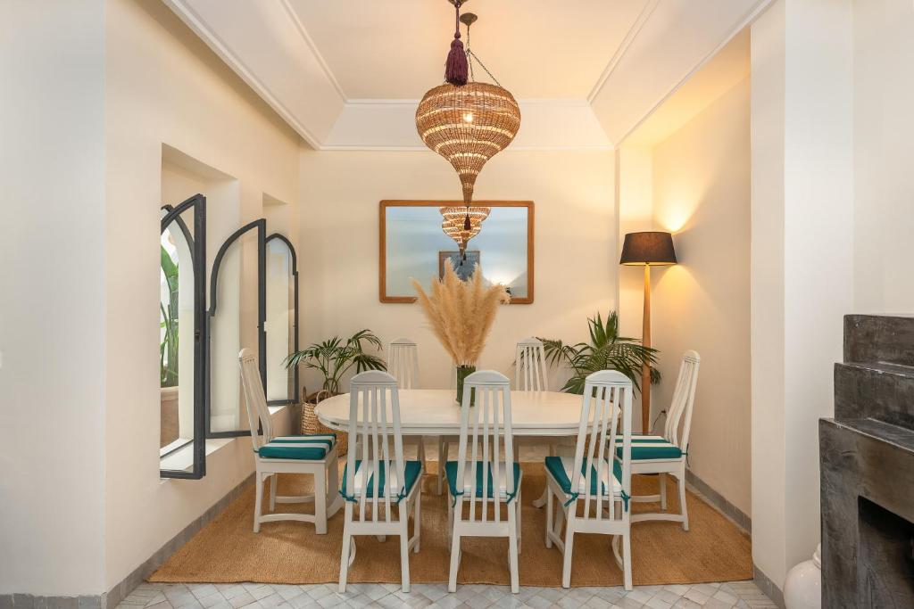 une salle à manger avec une table et des chaises blanches dans l'établissement Riad D'ari, à Marrakech