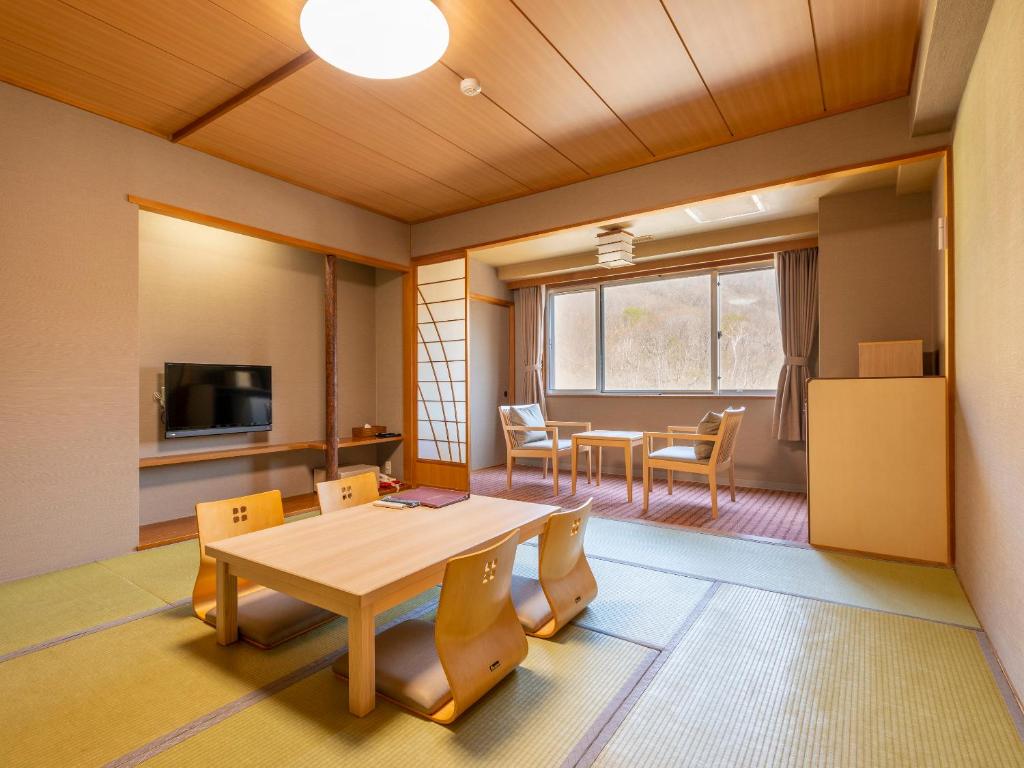 une pièce avec une table et des chaises et une salle à manger dans l'établissement Noboribetsu Manseikaku, à Noboribetsu