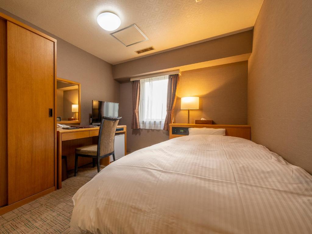une chambre d'hôtel avec un lit et un bureau avec un ordinateur dans l'établissement Noboribetsu Manseikaku, à Noboribetsu 23 autres photos