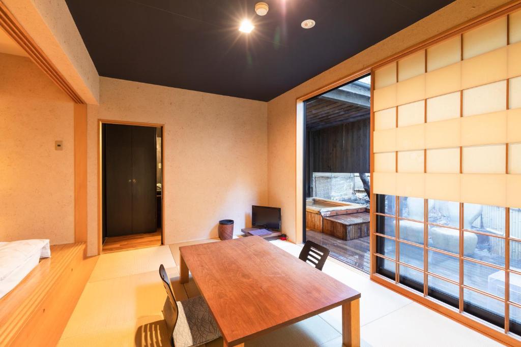 une salle à manger avec une table et une grande fenêtre dans l'établissement Yushintei, à Hakone