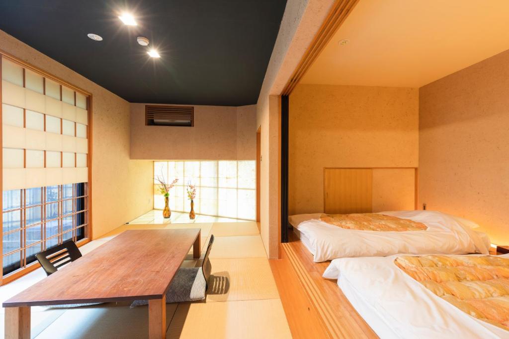 Cette chambre comprend une table, un lit et un bureau. dans l'établissement Yushintei, à Hakone 37 autres photos