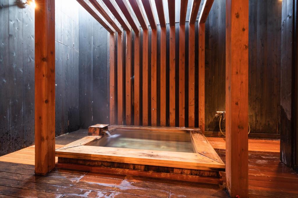 Cette chambre dispose d'une baignoire en bois et d'un mur en bois. dans l'établissement Yushintei, à Hakone