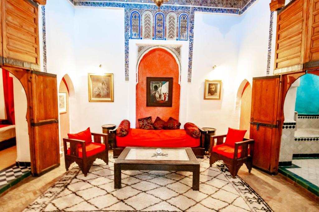 - un salon avec un canapé et des fauteuils rouges dans l'établissement Hotel & Spa Riad Dar El Aila, à Marrakech