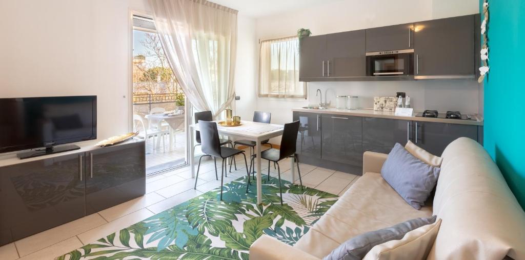 un salon avec un canapé et une table et une cuisine dans l'établissement D-Place Hotel & Suite, à Riccione