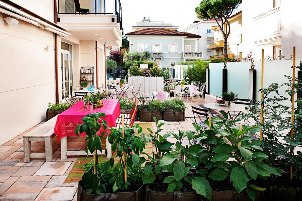 un patio avec une table rose et quelques plantes dans l'établissement D-Place Hotel & Suite, à Riccione
