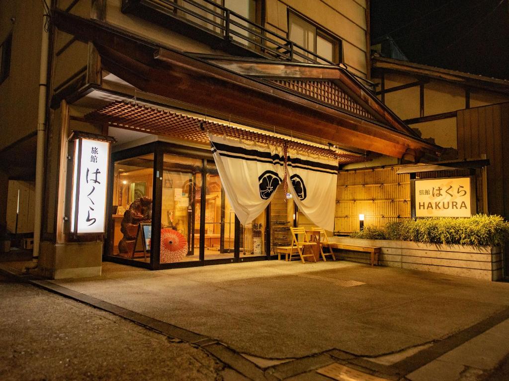 un devant de magasin avec un rideau devant un bâtiment dans l'établissement Ryokan Hakura, à Yamanouchi