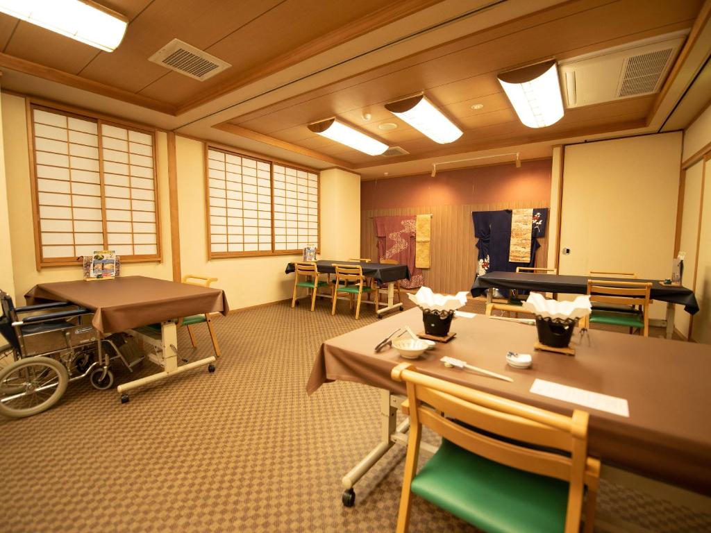 une chambre avec des tables et un fauteuil roulant dans l'établissement Ryokan Hakura, à Yamanouchi 74 autres photos