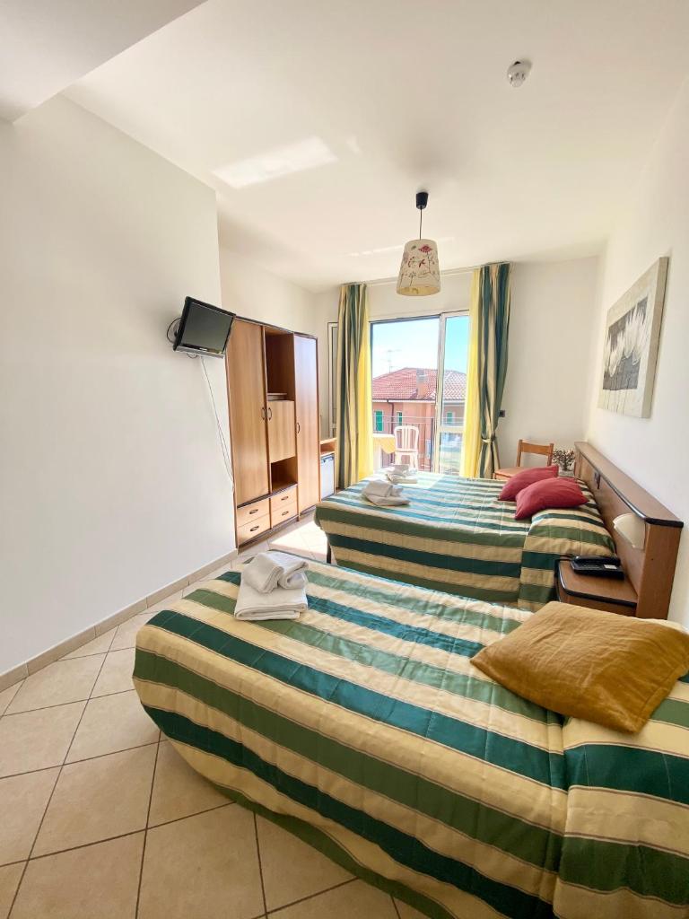 une chambre d'hôtel avec deux lits et une fenêtre dans l'établissement Albergo Villa Ada, à Borgio Verezzi