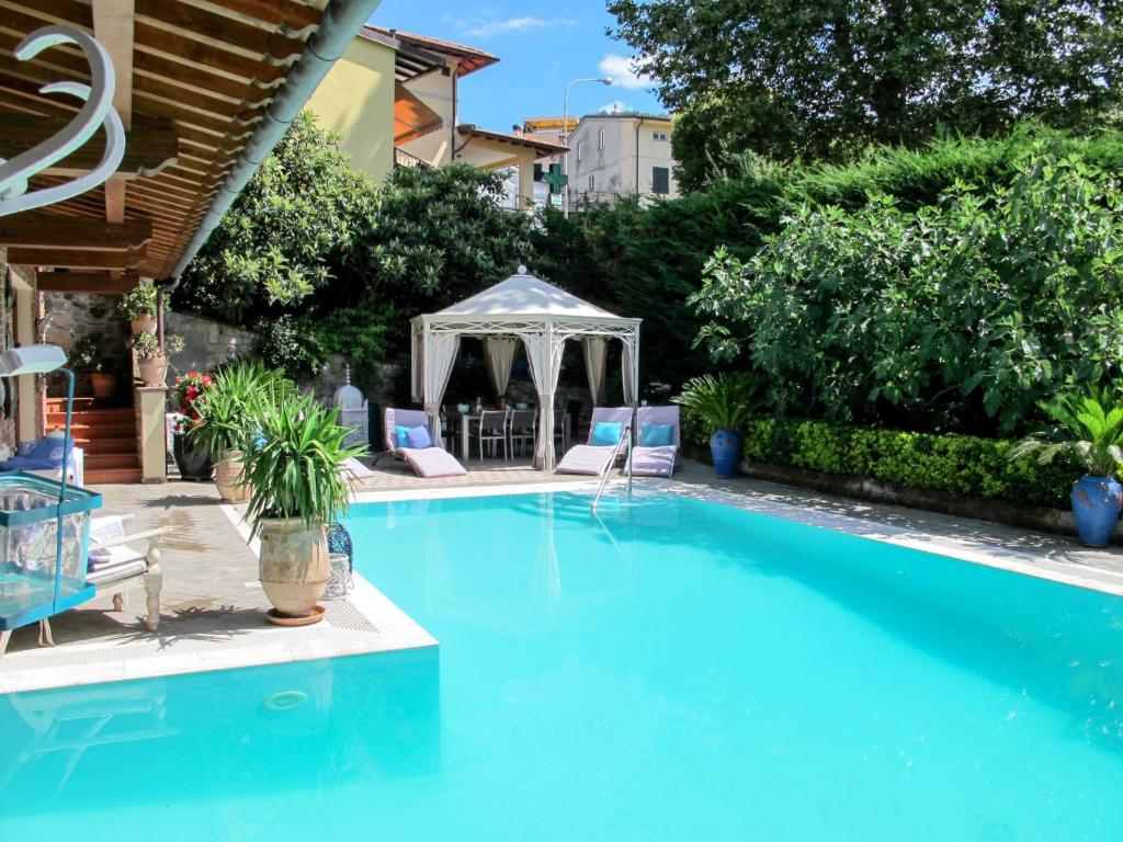 une piscine avec deux chaises et un gazebo dans l'établissement Villa Capo Corso by Interhome, à Corsanico-Bargecchia