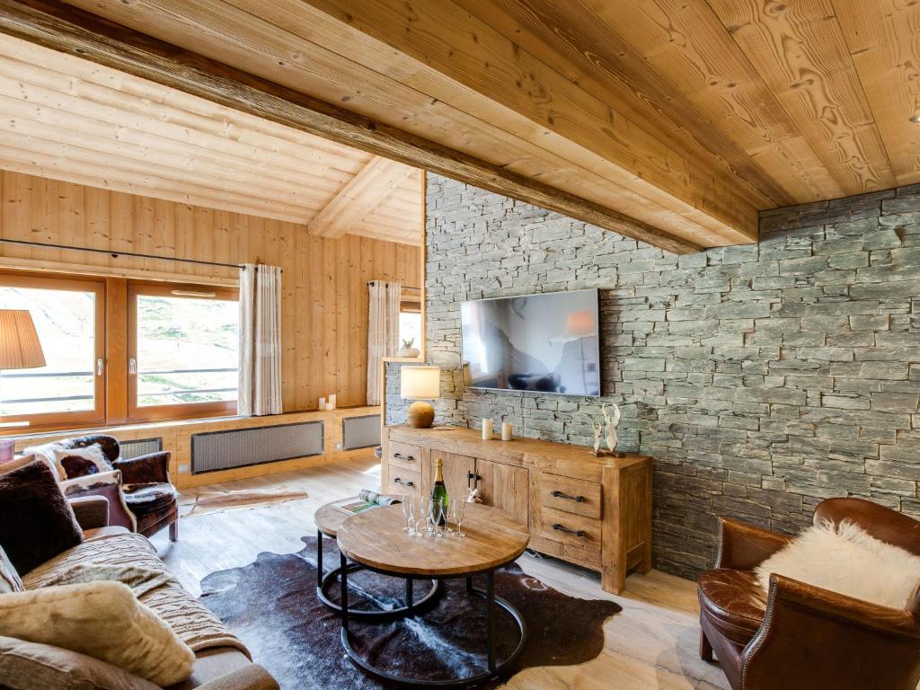 un salon avec un mur en pierre dans l'établissement Apartment Grand Roc - Val Claret-2 by Interhome, à Tignes