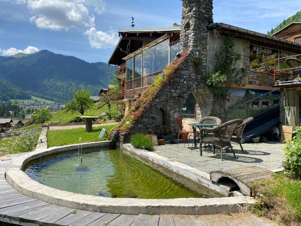 une maison avec un étang en face de celle-ci dans l'établissement Chalet Génépi, à Montriond