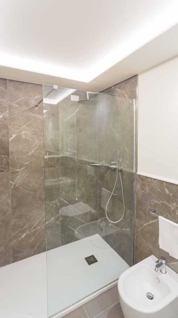 une salle de bain avec une douche, des toilettes et un lavabo dans l'établissement Hellenia Yachting Hotel & SPA, à Giardini Naxos