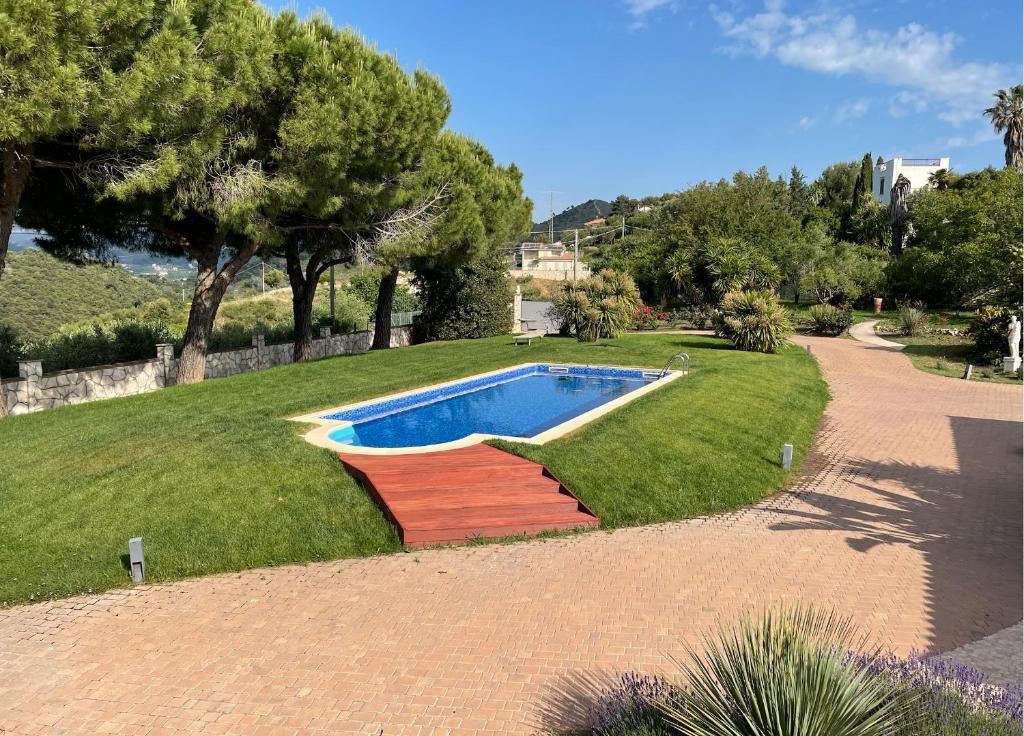 une piscine au milieu d'une pelouse avec des arbres dans l'établissement Villa Camporosso, à Camporosso