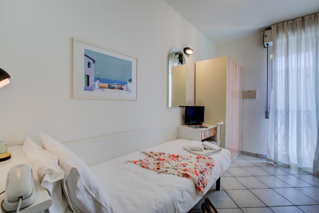une chambre avec un lit, une table et une fenêtre dans l'établissement Hotel Christian Ideale Per Famiglie, à Riccione