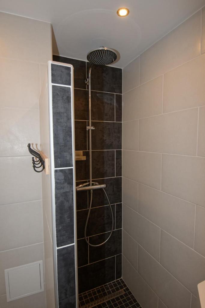 une douche avec une porte vitrée dans une salle de bain dans l'établissement Miellerie du lac, à Gérardmer 5 autres photos