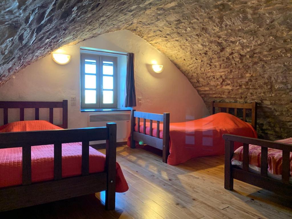 une chambre avec deux lits et une fenêtre dans l'établissement Gîte du Dolmen de l'Hom, à Le Massegros