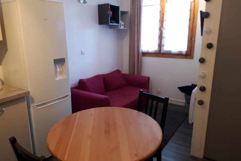 un salon avec une table et un canapé rouge dans l'établissement Appartement confortable face à la montagne, à Aime La Plagne