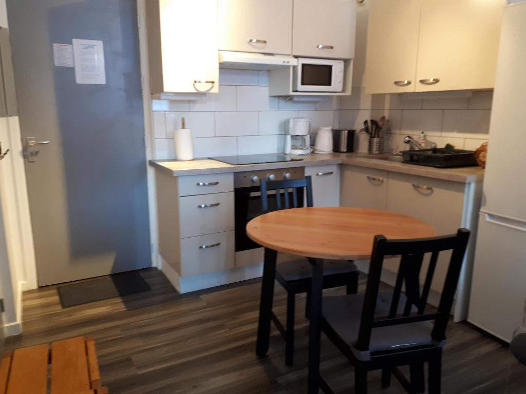 une cuisine avec une table en bois et une petite table et des chaises dans l'établissement Appartement confortable face à la montagne, à Aime La Plagne