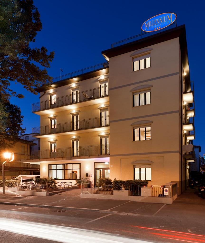 Un grand bâtiment blanc avec un panneau en haut dans l'établissement Residence Millennium, à Rimini