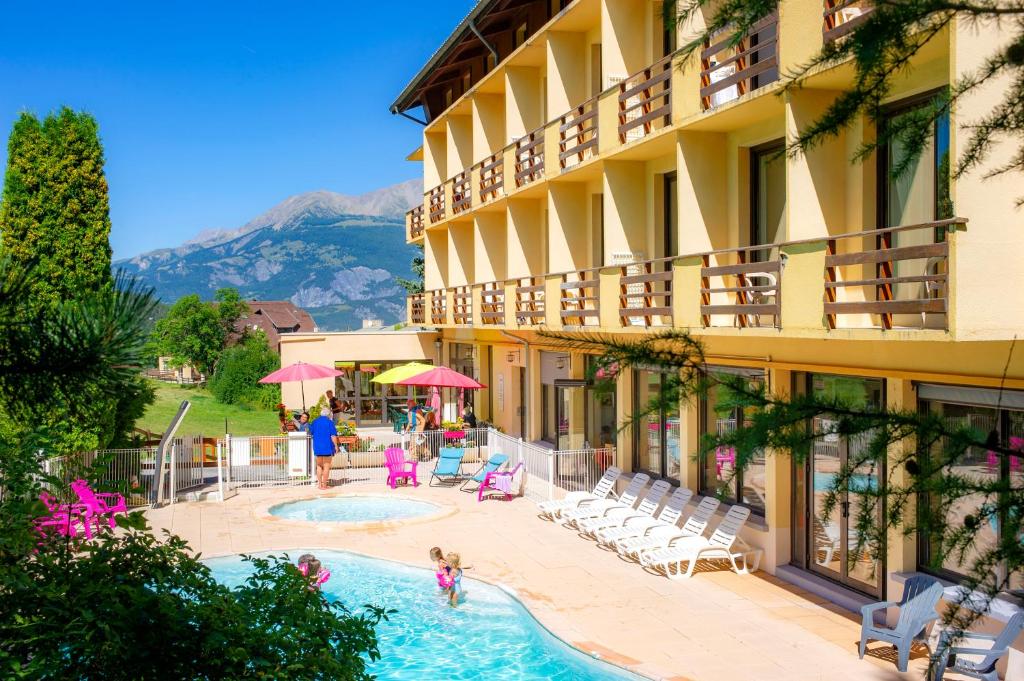 un hôtel avec une piscine devant un immeuble dans l'établissement VTF Les Balcons du Sauze, au Sauze