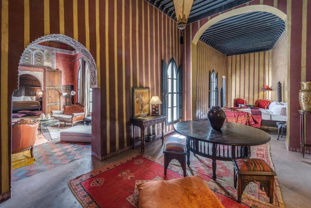un salon avec une table et une chambre dans l'établissement Dar Darma, à Marrakech