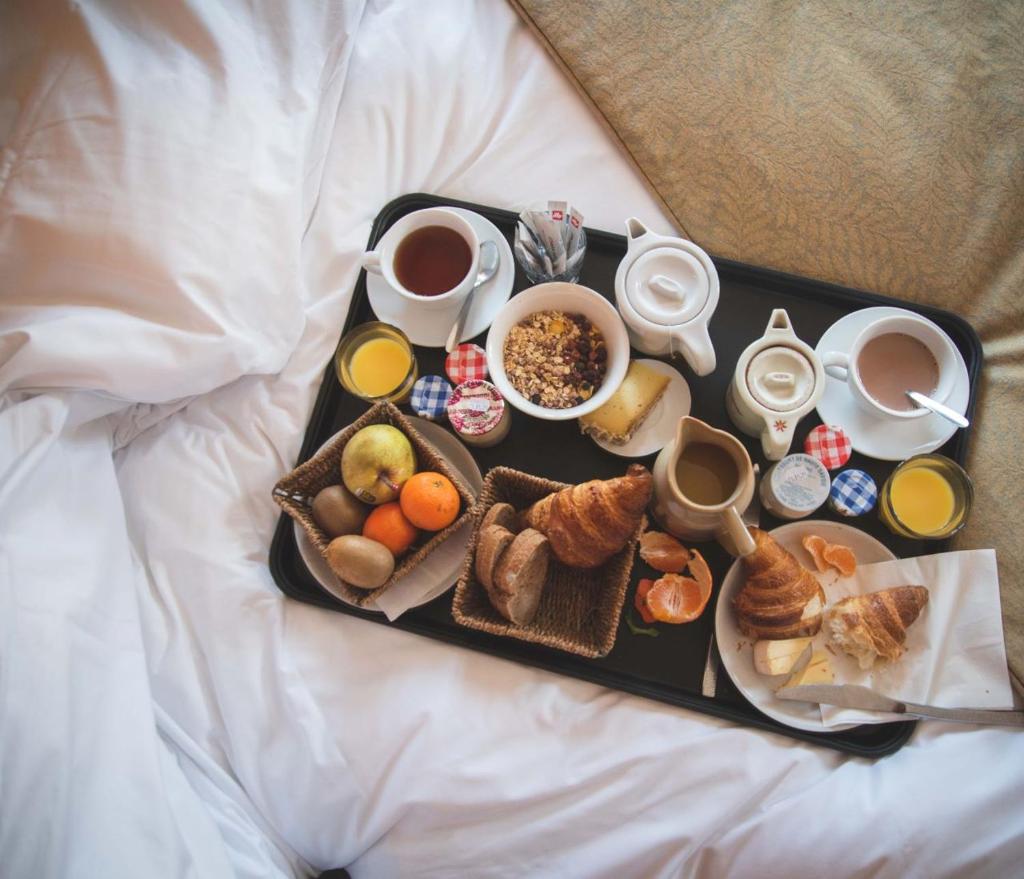 - un plateau de produits pour le petit-déjeuner et du café sur un lit dans l'établissement La Ferme, à La Clusaz