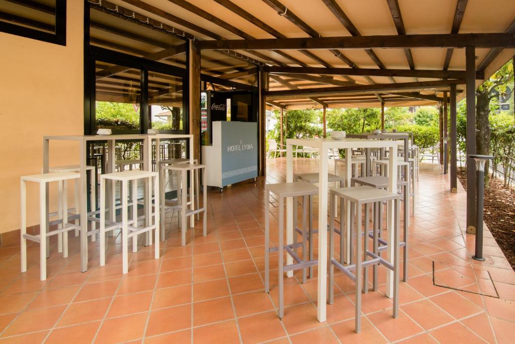 un groupe de tabourets blancs sous une structure métallique dans l'établissement Hotel Lydia, à Cervia 72 autres photos