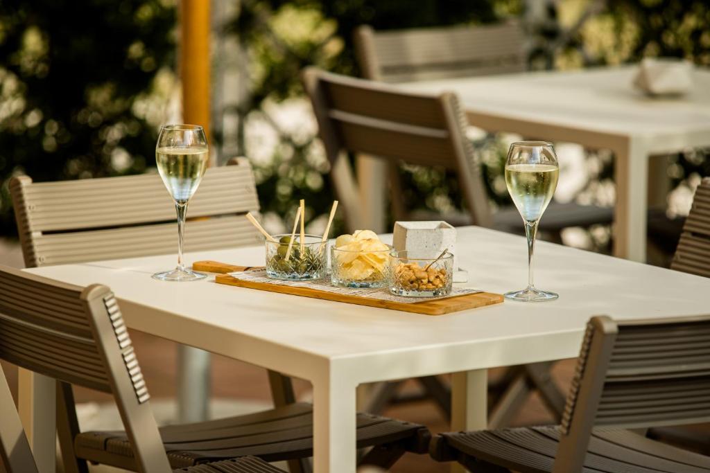- une table blanche avec deux verres de vin dans l'établissement Hotel Lydia, à Cervia