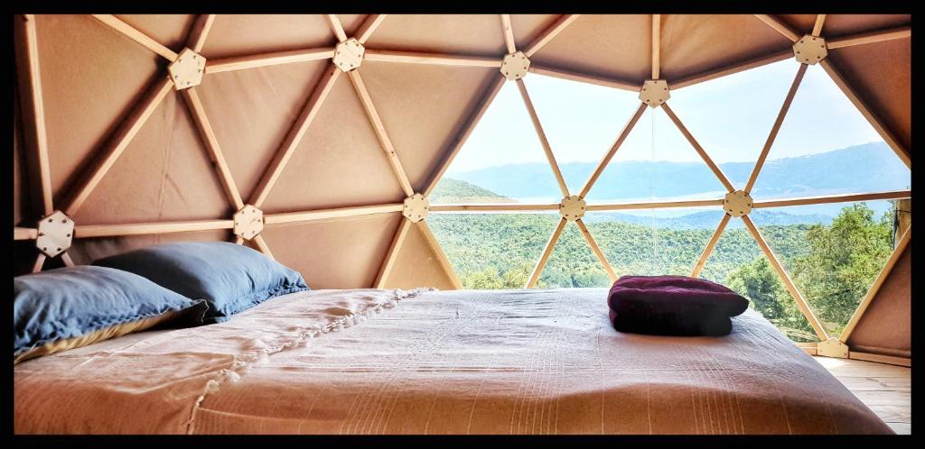 - une chambre avec une grande fenêtre dans une yourte dans l'établissement Sottu E Stelle, à Albitreccia 8 autres photos