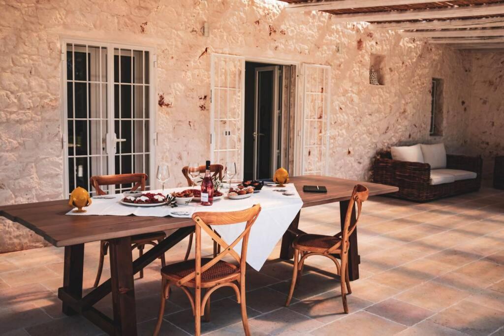 une salle à manger avec une table et des chaises dans l'établissement Tenuta Trullo Acquaro Ostuni, à Ostuni